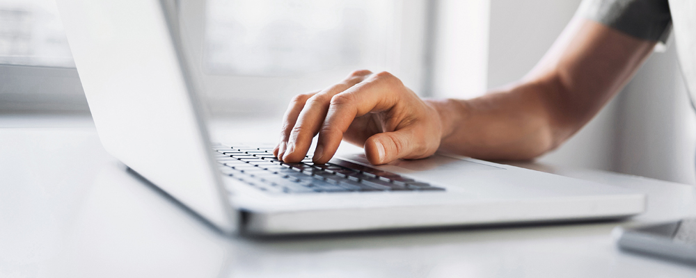 Hand on laptop keyboard