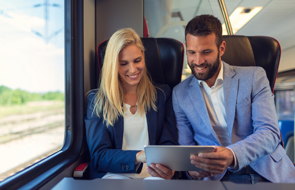 Smiling business woman is showing something on her iPad to her male colleague